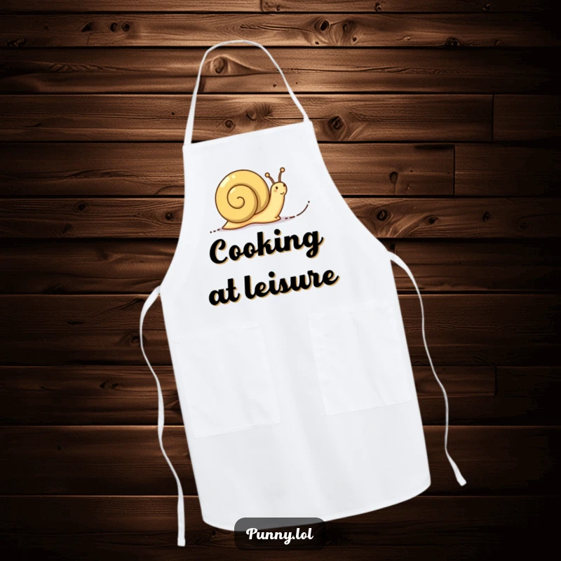 Funny Determined Snail Apron: A chef's apron showing a determined snail leaving a trail of words, symbolizing measured progress in the kitchen.