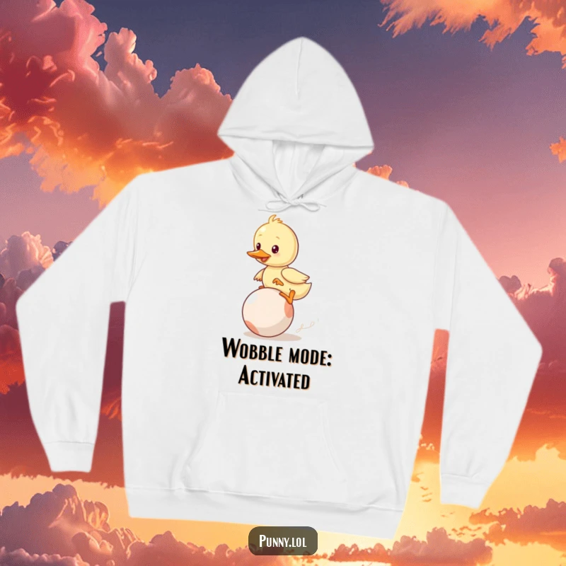 Funny Duckling Hoodie: A determined duckling hilariously wobbles while attempting to ride a bouncing ball, perfect for cozy laughs.
